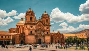 View of a historic church in Cuzco, Peru with a bustling city street.