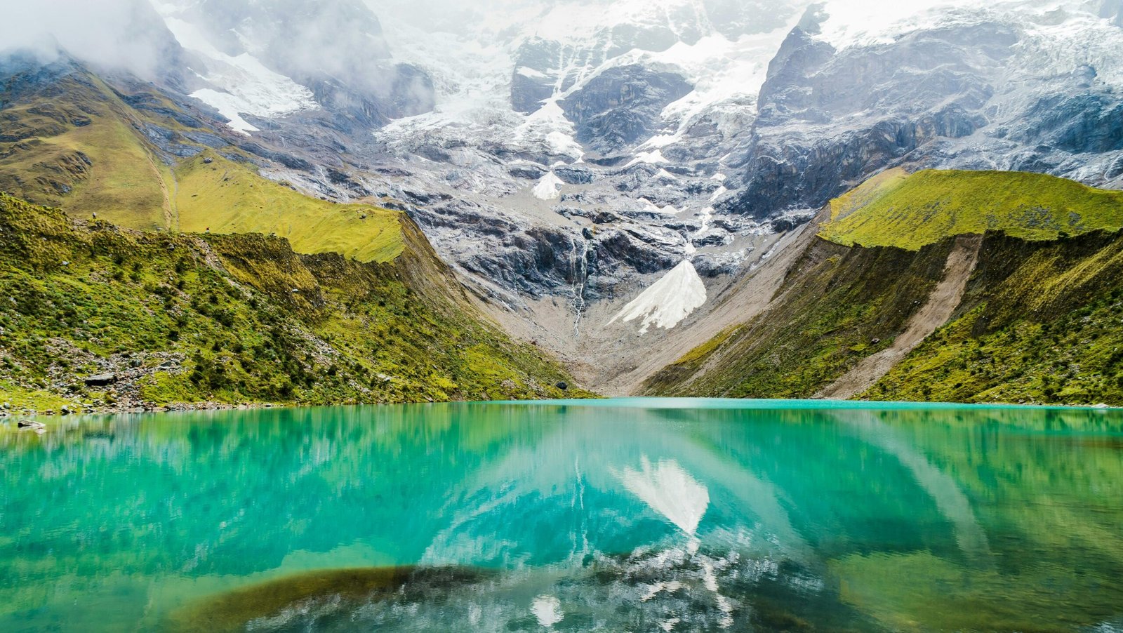A serene lake reflecting snowcapped mountains, showcasing pristine natural landscapes.