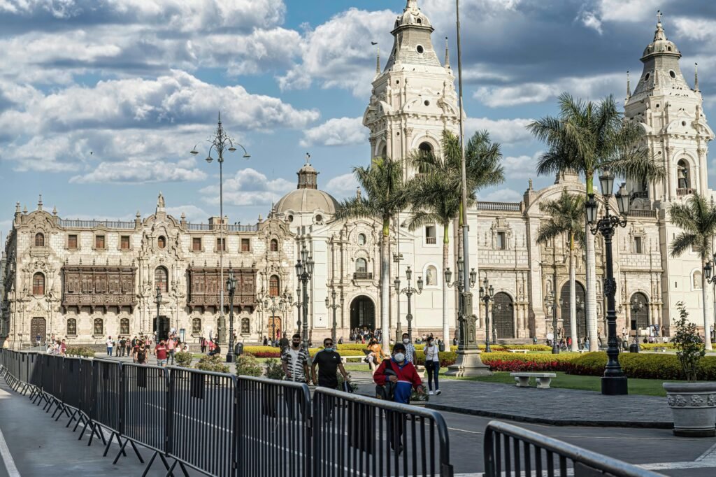 A bustling Plaza Mayor in Lima showcasing the historic Cathedral of Lima under blue skies.
