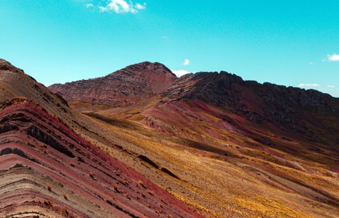 Stunning view of Vinicunca Rainbow Mountain in Ancahuasi, Peru with vibrant colors under a clear sky.